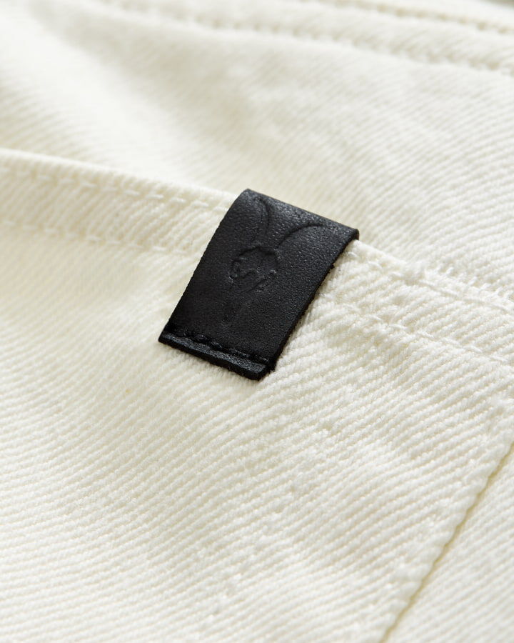 Closeup of the leather AllSaints jeans label.