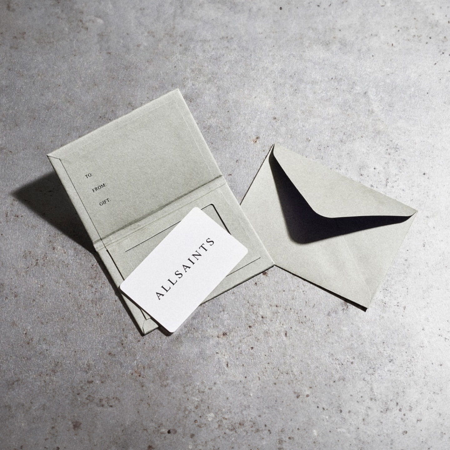 Photograph showing a set of AllSaints GiftCards on a textured stone