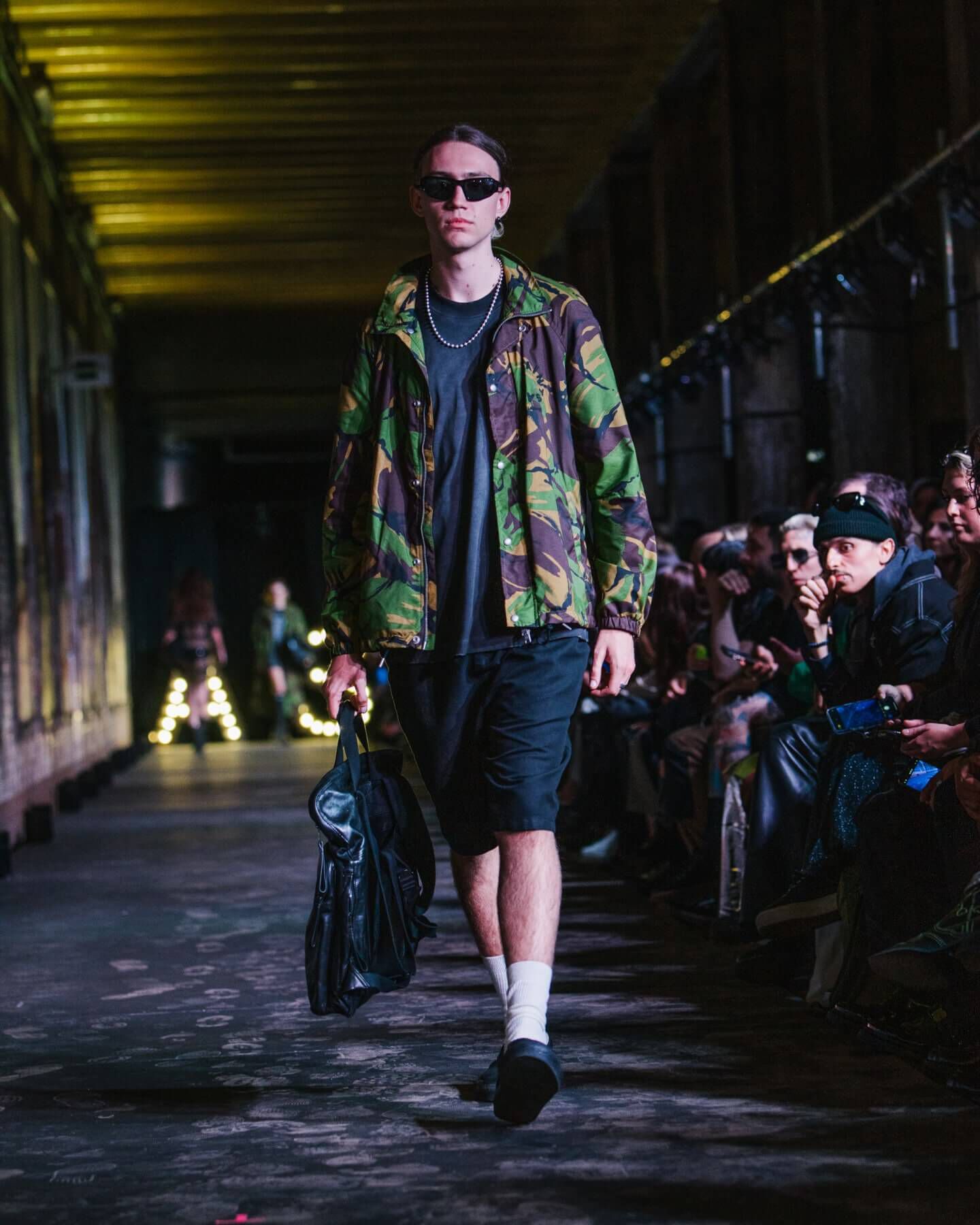 Man wearing camo jacket and black shorts on a catwalk