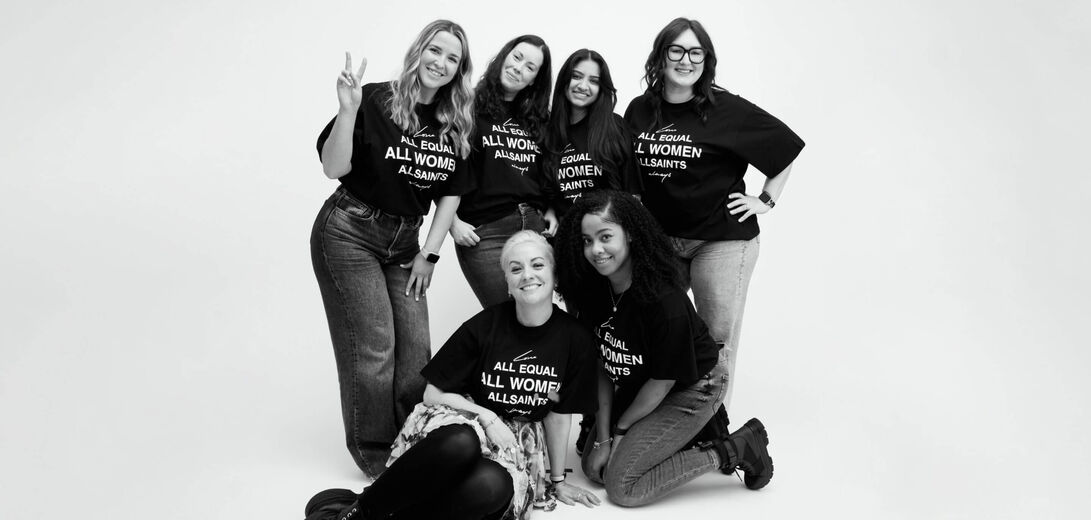 A black and white image of female AllSaints staff wearing a print t-shirt.