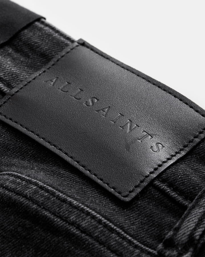 Closeup of the leather AllSaints jeans label.